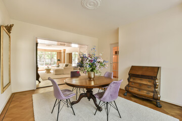 a dining room with purple chairs and a wooden table in the center of the room is an old piano case