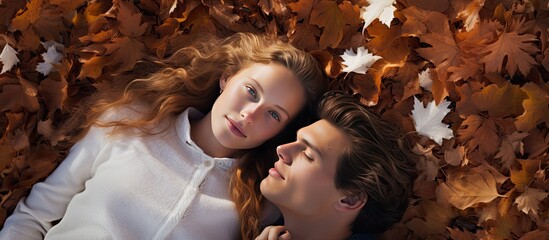 Autumn leaves beneath young couple in garden