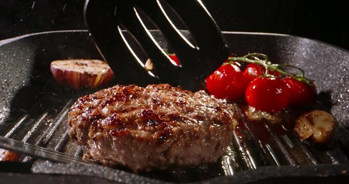 Chef takes frying beef halal cutlet and turns around using kitchen spatulas on pan preparing Burger. Cinematic advertising burger cooking. High-protein food option diet, delicious, pan-fried cutlets.