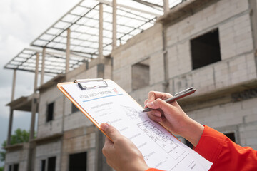 The architect or project engineer is checking on house building quality checklist for inspecting...
