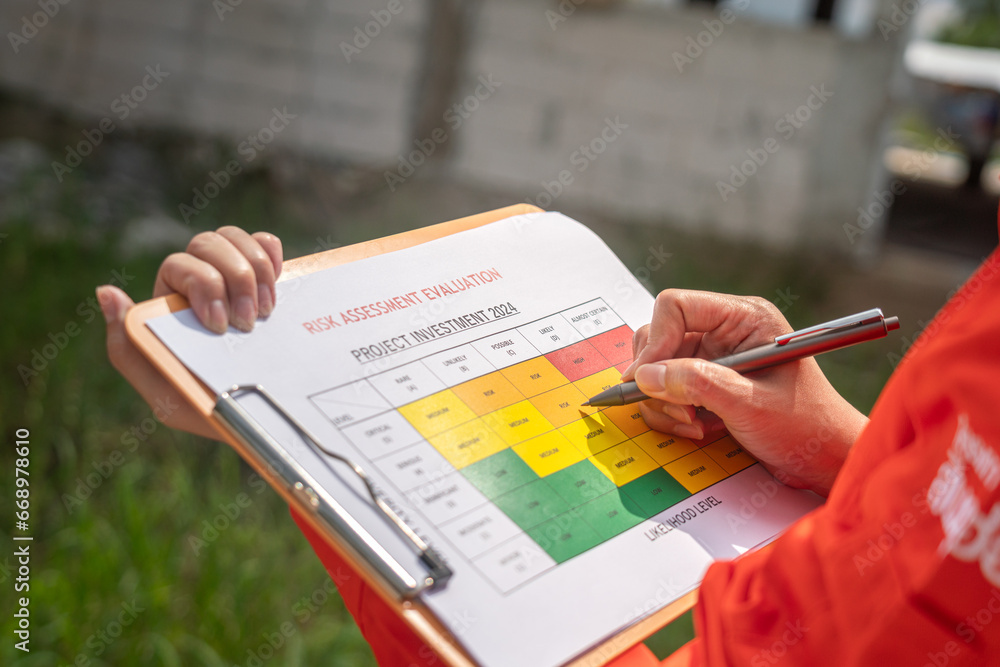 Wall mural action of the project engineer is rating on risk assessment form to evaluate the project investment 