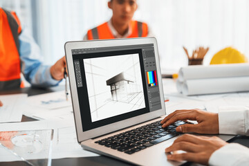 Engineer and architect working together brainstorming and designing blueprint using laptop working with architectural software for precise digital interior or structure design. Insight