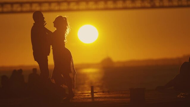 Elderly couple - dancer's silhouette with setting sun.
