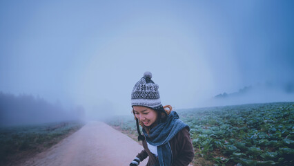 Obraz premium Asian women relax in the holiday. Happy to travel in the holiday. During the foggy winter