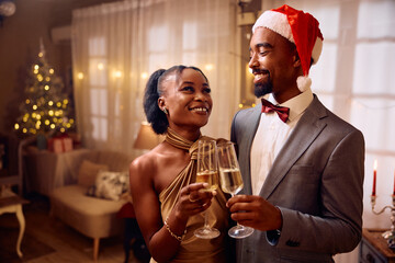 Happy black couple toasting with champagne on New Year's Eve.