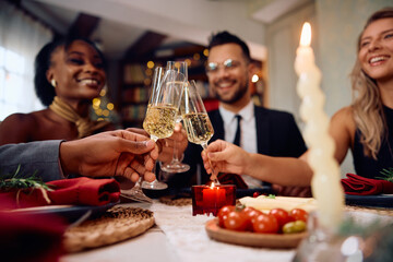 Close up of friends toasting with champagne during New Year's dinner party.