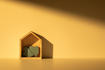 Love is at home. Two heart-shaped ornaments in wooden house. Emotional expression.