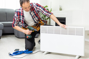 service man with wrench near radiator