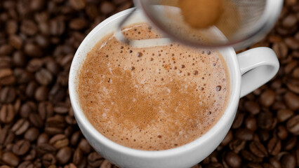 Coffee with cinnamon. Sprinkle cinnamon powder over coffee foam
