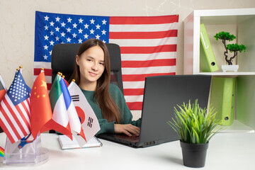 language learning online, Student in a foreign language class, surrounded by flags, studying to...