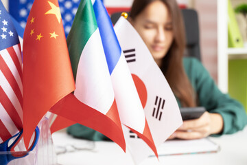 Online language course, teenager with a mobile app, flags of different countries, eLearning
