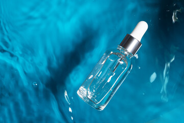 serum in the rippling blue water, oil for face with hyaluronic acid for moisturizing and youthful...