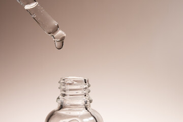 facial serum oil dripping from a pipette into a bottle, natural cosmetics for moisturizing and beautiful skin