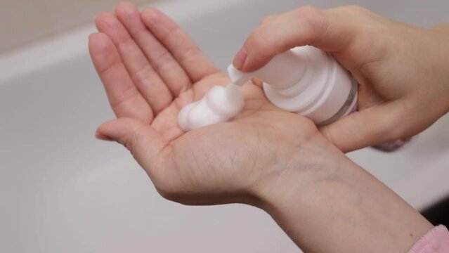 foam for face, Facial skin care, women's hands with skin cleansing foam in bathroom