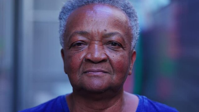 Close-up face of a senior black woman looking at camera in neutral expression. Portrait of African American elderly lady