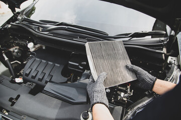 Auto mechanic holding old car air filter pollution to checking cleaning and replacing new for fix heat car air conditioner service maintenance. - obrazy, fototapety, plakaty