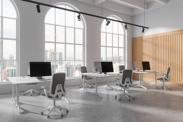 Elegant workplace interior with pc monitors on table in row, panoramic window
