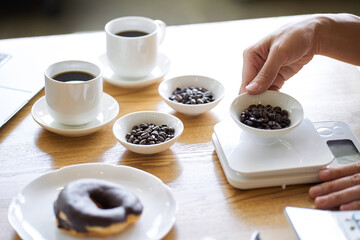 コーヒー豆の重さを量るアジア人経営者