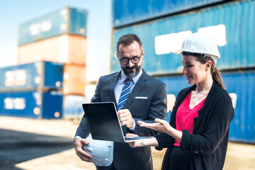 Container container logistic engineer woman  working on laptop with businessman in container shipping  port