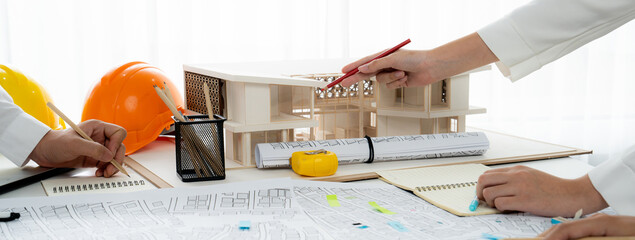 Worker, architect and engineer work on real estate construction project oratory planning with...