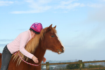 Love is, pretty young woman and her pretty chestnut pony horse share an emotional moment as she...