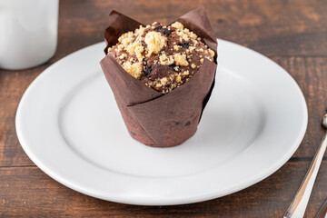 Chocolate muffin or cupcake with coffee on wooden table
