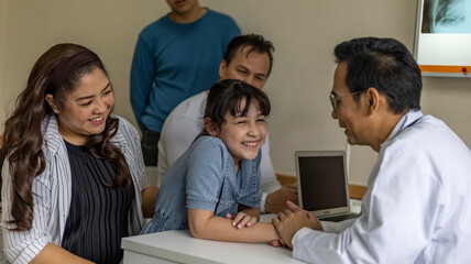 A girl gets good care from a male doctor by holding his hand with feeling good and listening the result from her diagnosis. Doctor takes care his patient with warm hospitality.