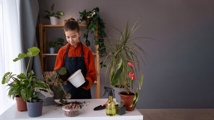 Child girl gardener wearing rubber protective gloves and apron taking care of home garden, favorite hobby