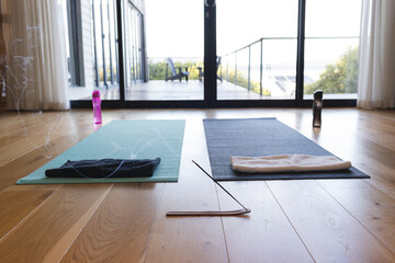 Exercising mats, bidons and incense left in sunny room
