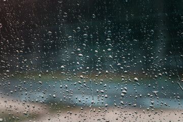 Close-up of raindrops on a window glass on a blurred background
