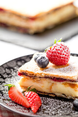 A piece of Napoleon cake with poppy seeds and cherries