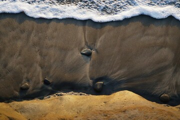 a close up of a water wave with some rocks near it