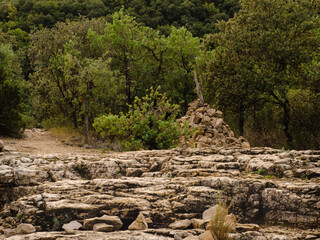 cairn surmonté d'un bâton avec végétation provencale de garrigue