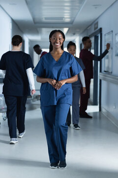 Portrait of happy african american female doctor wearing scrubs in hospital