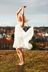 Woman, happiness and dancing on vacation, summer and outdoor for holiday, smiling and city. Wind,...