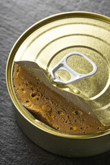 Liver pate, beef pate in the metal can, with knife spread, takes with knife, open can of pate, black background, close up, for banners