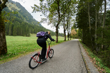 Fototapeta na wymiar Mit dem Roller rasant unterwegs durch die herbstliche Bergwelt der Allgäuer Alpen