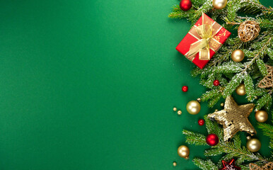 Beautiful green Christmas background with a border of fir branches, golden Christmas toys, stars...