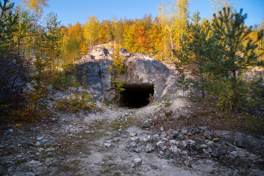 Entrance to the tunnels, old abandoned quarry mines near the city of Sataniv, Ukraine. Autumn day. Stones and wood
