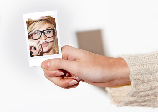 Hand, photograph of a woman with a finger mustache and print in studio isolated on a white background. Face, photo booth picture and a young person closeup at a party or event for celebration