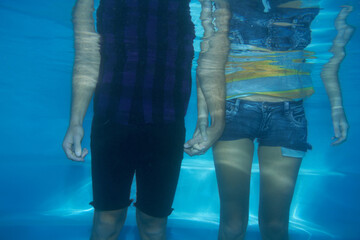 Couple, clothes or underwater swimming pool or fashion, trendy style or holding hands. Male person,...