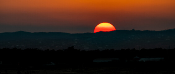 View of the sun setting on at the sunset.