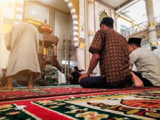 Group of muslim man praying inside the mosque. Muslim praying together. Islamic prayer