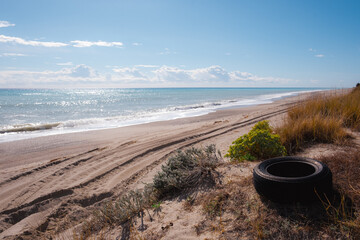 Wonderful italian beach with a old tyre on the sand