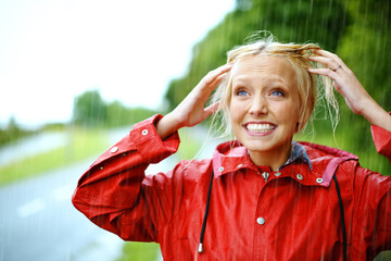Woman, smile and raincoat or hands in storm, wet and cold from weather, winter and nature. Happy female person, fashion and red jacket is trendy, rainfall and protection from water, face and playful