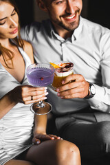 A couple in love drinks a cocktail and smokes a hookah on the terrace at night. Nightlife concept