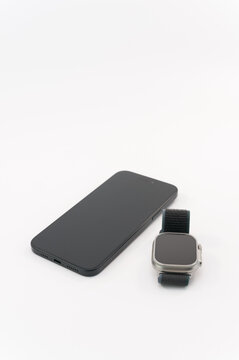 immagine editoriale illustrativa primo piano di Apple Watch Ultra 2 e Apple iPhone 15 Plus in evidenza su superficie bianca
