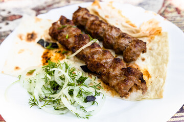 portion of kebabs on plate close up in Armenian village outdoor restaurant