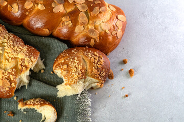 A Challah bread, known as Polish Chalka, is presented on a marble table, topped with sweet crumbs...