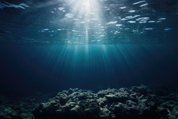 Fototapeta na wymiar Deep blue ocean floor with reefs. Empty ocean bottom. Sun rays shining through the water surface. Deep blue and teal.